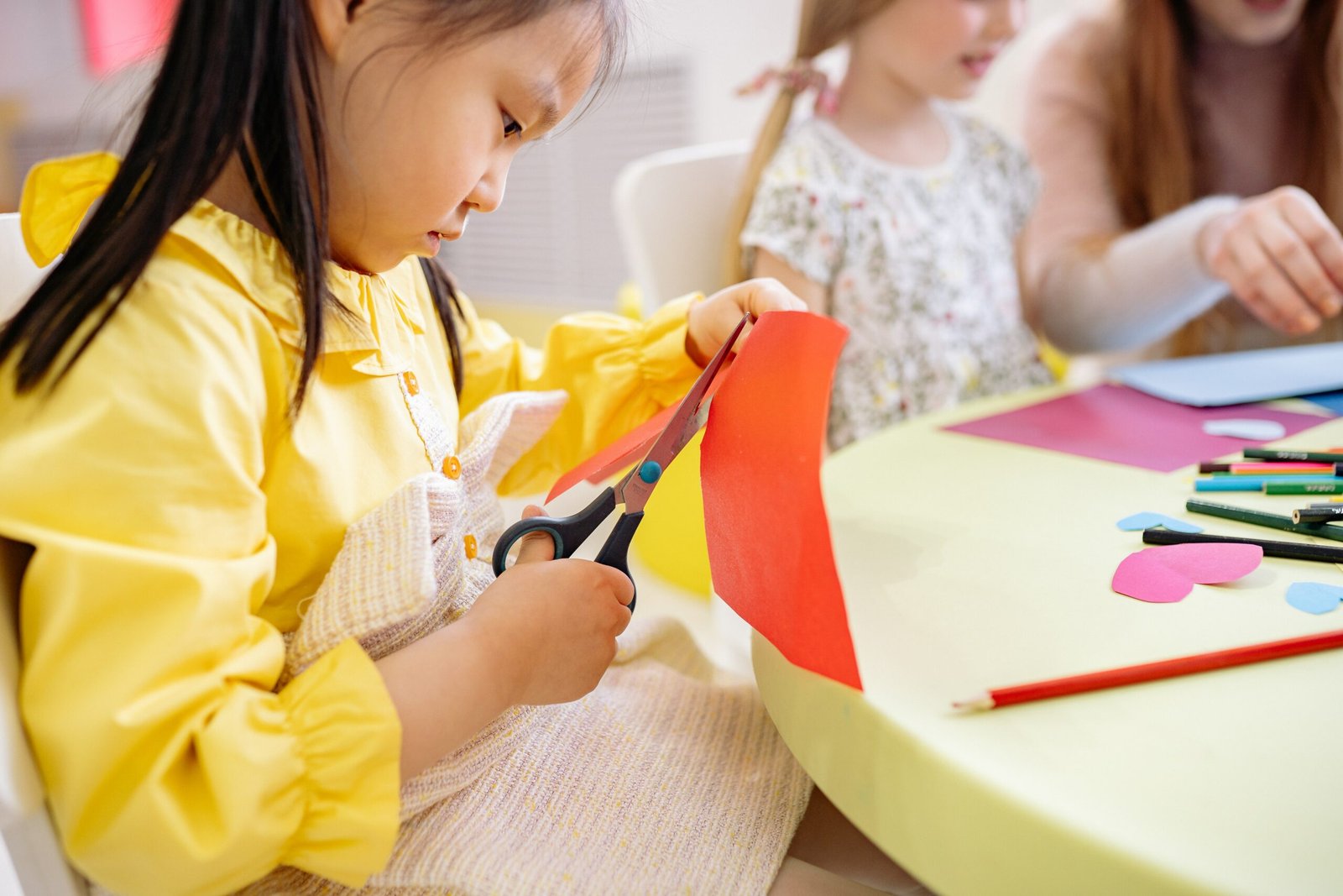 young child cutting up coloured paper